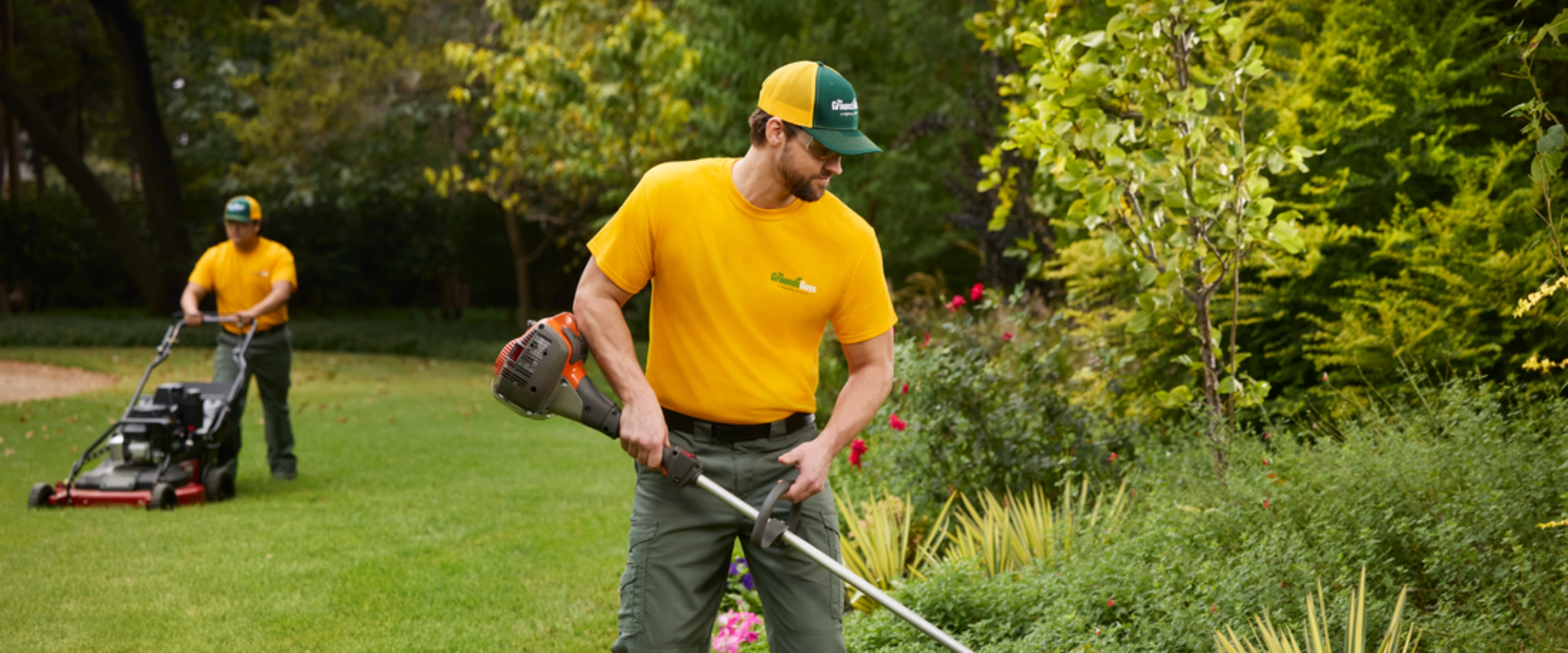 The Grounds Guys branded truck and male technician.